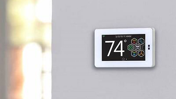 A thermostat on a wall displaying 74°F temperature