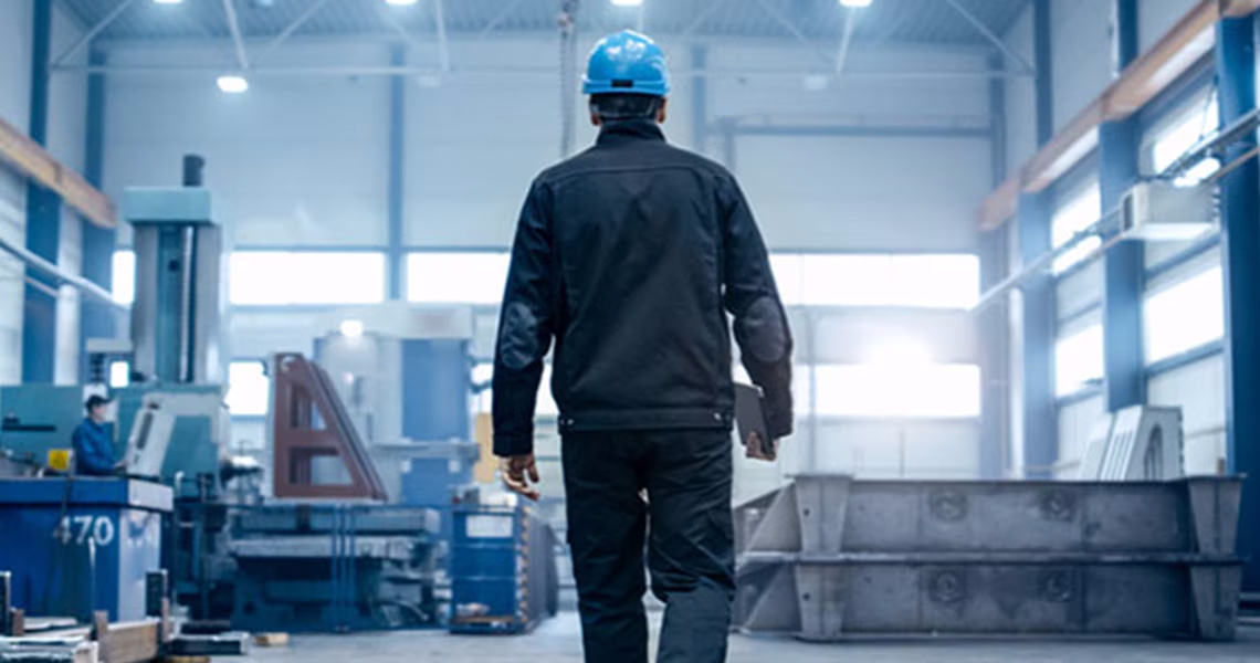 Back-view of a man walking in a factory