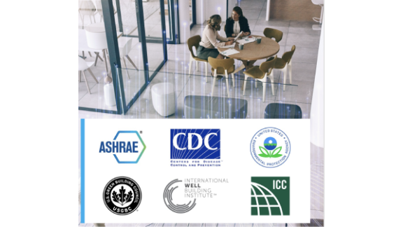 Interior of a cafe, where two women are chatting at a table, with a collage of logos of various American associations
