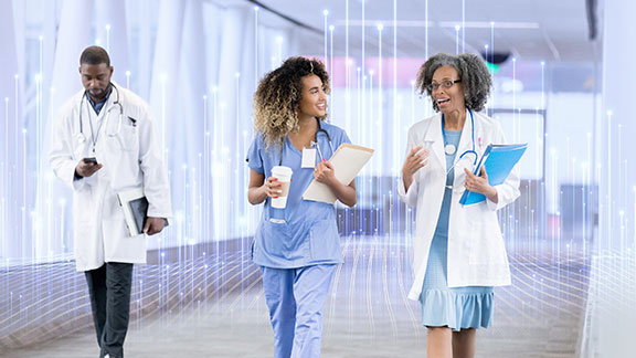 Doctors and nurses conversing and walking along a passage in a hospital